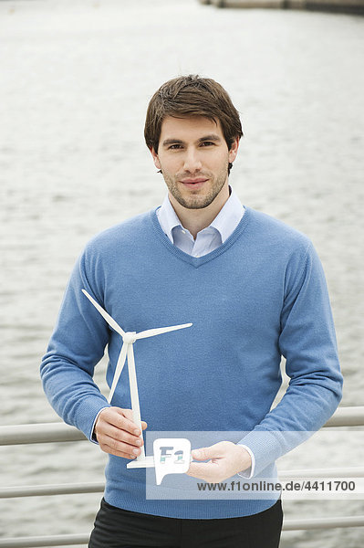 Deutschland  Hamburg  Kaufmann mit Windkraftanlage  Portrait