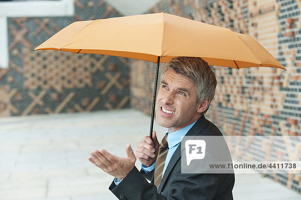 Deutschland  Hamburg  Geschäftsmann mit Schirm
