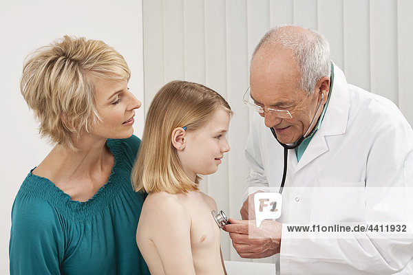 Doctor examining girl (8-9) with woman