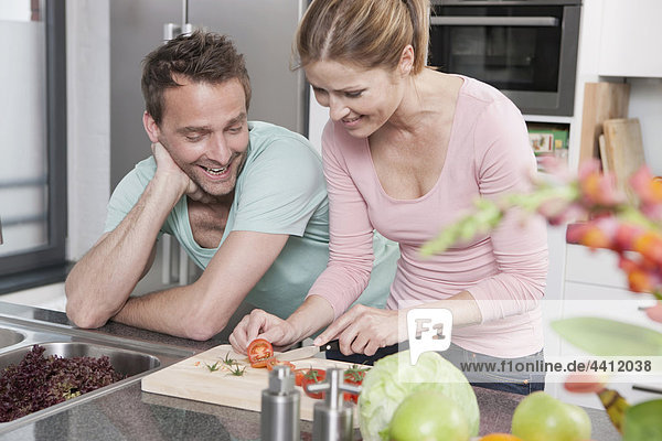 Deutschland  Paar Zubereitung Salat in der Küche  lächelnd