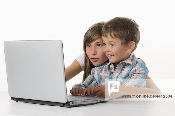 Mädchen und Junge (2-5) mit Laptop  lächelnd