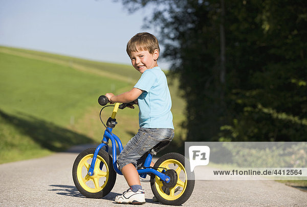 Austria  Mondsee  Boy (2-3) riding bicycle  smiling  portrait
