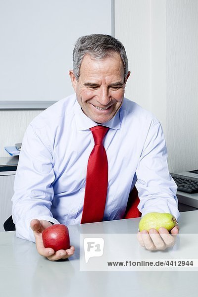 Businessman holding apple and pear
