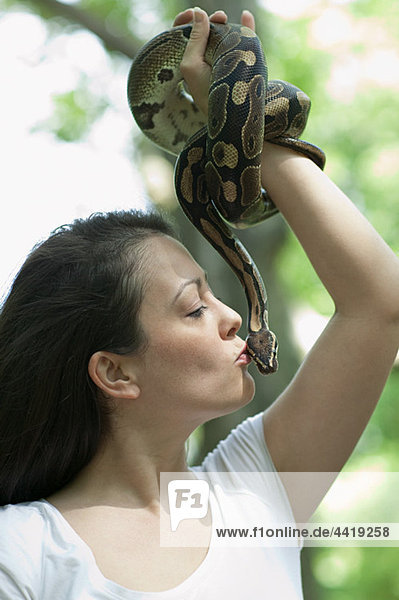 Woman kissing a snake