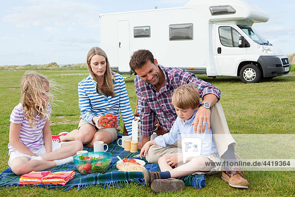 Familie beim Picknick mit dem Wohnwagen