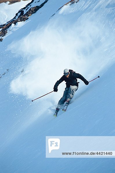 Man telemark skiing on steep mountain slope