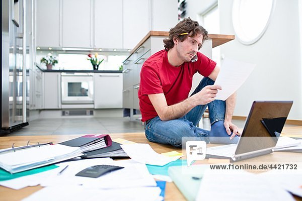 Mid- adult man struggling with domestic paperwork
