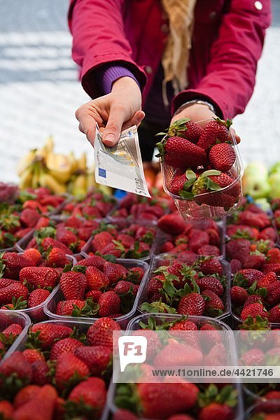 Nahaufnahme Mitte Abschnitt Frau Zahlung für Korb mit Erdbeeren