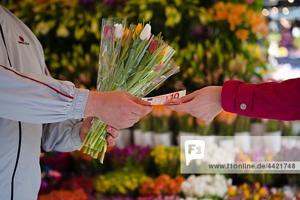 Woman paying for bunch of flowers