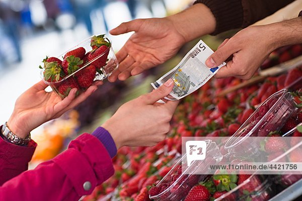 Woman paying for basket of strawberries