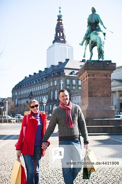 Paar mit Einkaufstaschen  zu Fuß in der Stadt