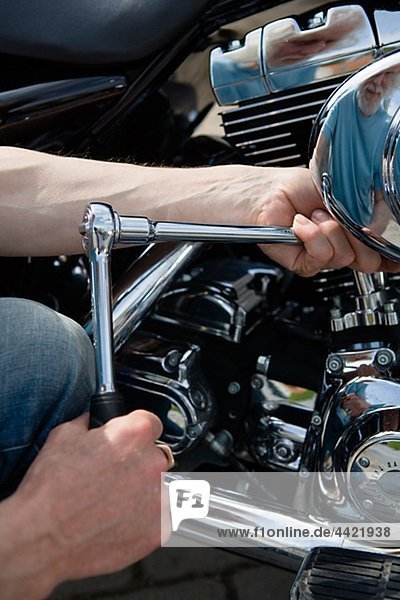Close-up of man repairing vintage motorbike