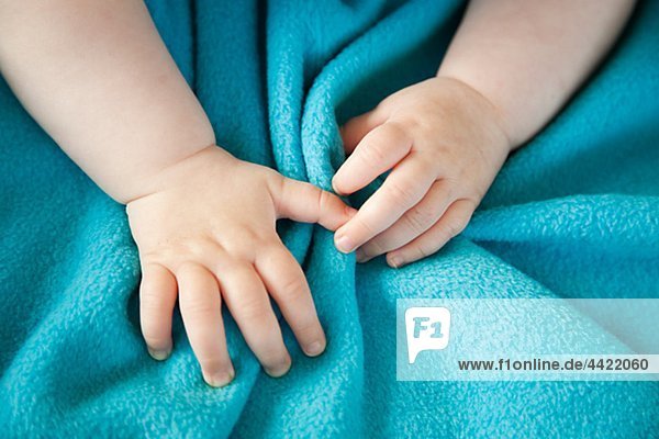 Nahaufnahme des Babys Hand auf Blau Bogen