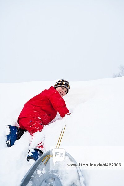 Junge spielt auf Schnee