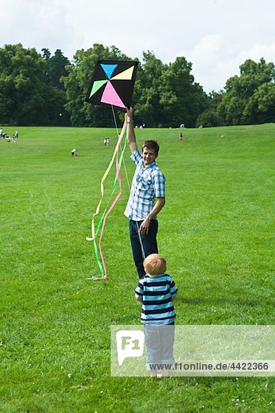 father with son playing with kite