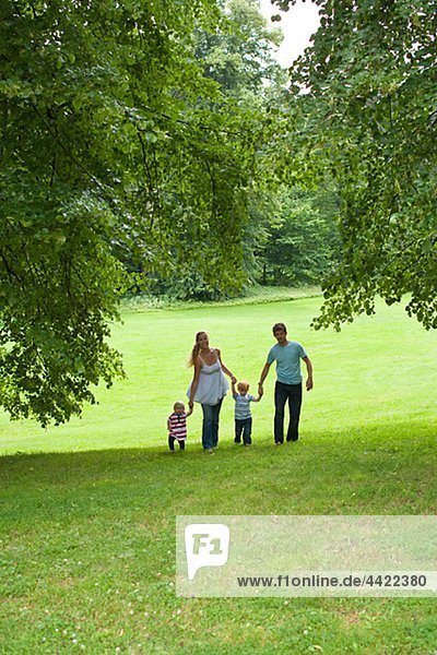 Parents walking with children in park