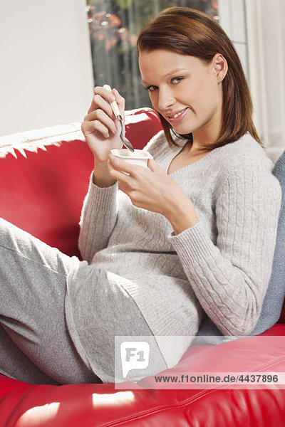 Young woman eating a yogurt