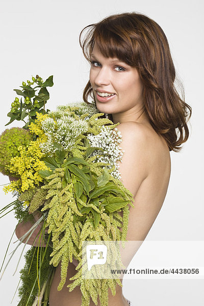 Junge Frau  die die Brust mit Blumen bedeckt