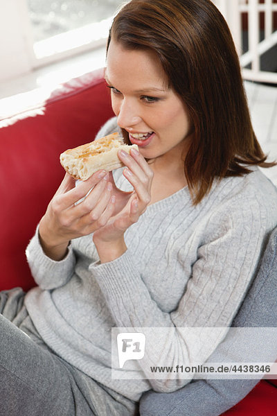 Junge Frau isst Brotscheibe