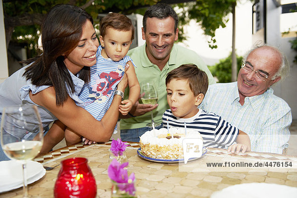 Family blowing candles out on cake