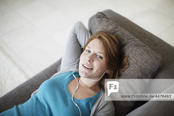 liegend  liegen  liegt  liegendes  liegender  liegende  daliegen  Fröhlichkeit  Couch  Kopfhörer  Mädchen