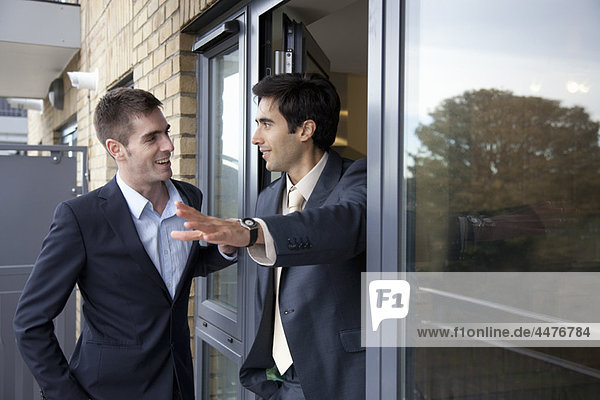 Two businessmen outside apartment
