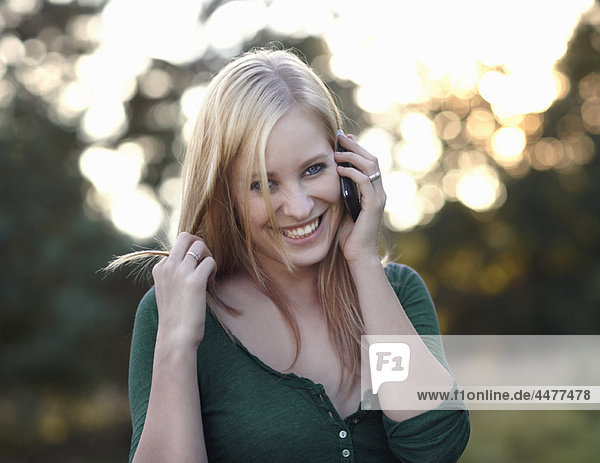 Frauen lächeln mit dem Handy in der Natur