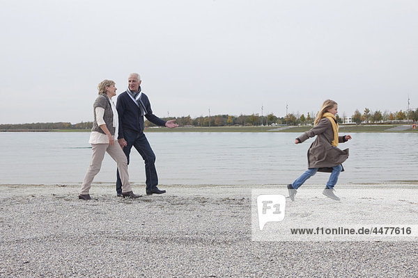 Großeltern und Mädchen beim Spaziergang am See