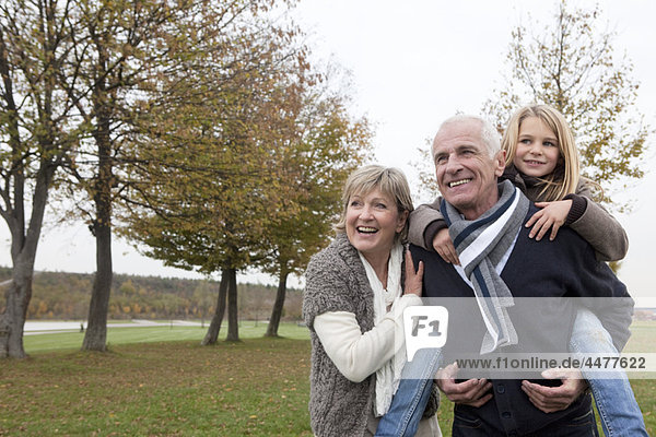 Großeltern und Enkelin im Herbst