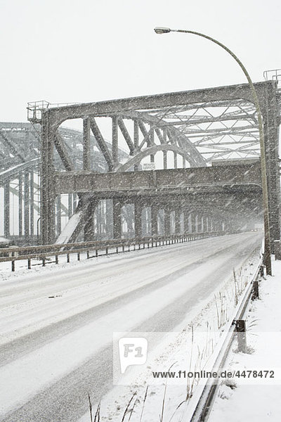 Ein Schneesturm über eine Straßenbrücke