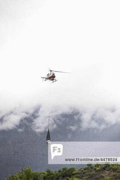 Hubschrauber  der Vorräte über Land transportiert