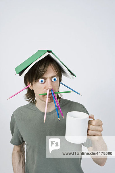 Bizarrer Mann mit Bleistiften  Buch und Kaffee