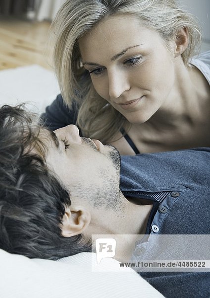 Young couple in bed looking at each other