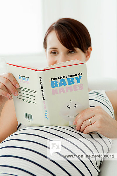 Schwangere mit Babynamensbuch