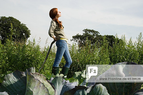 Young woman standing in cabbage field