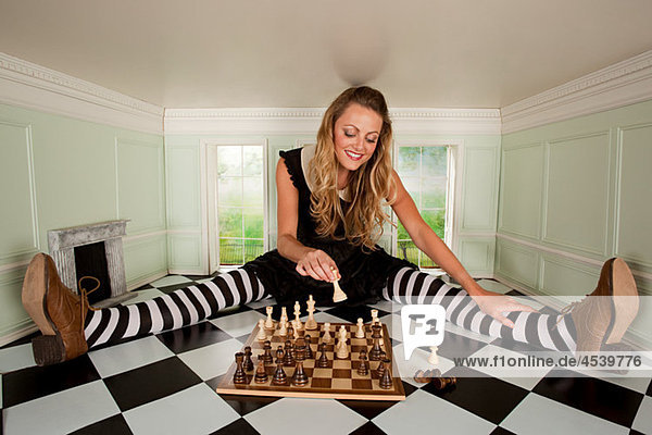 Young woman in small room with chess set