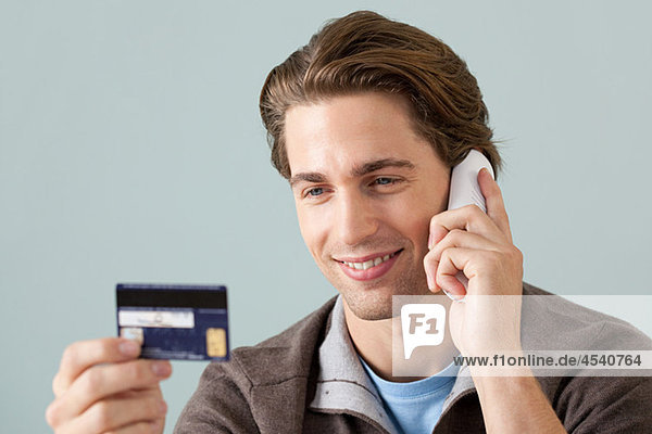 Young man on the phone with credit card