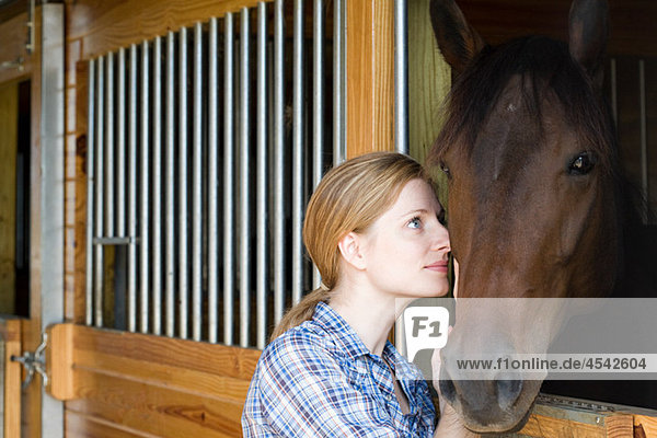 Mittlere erwachsene Frau mit Pferd im Stall