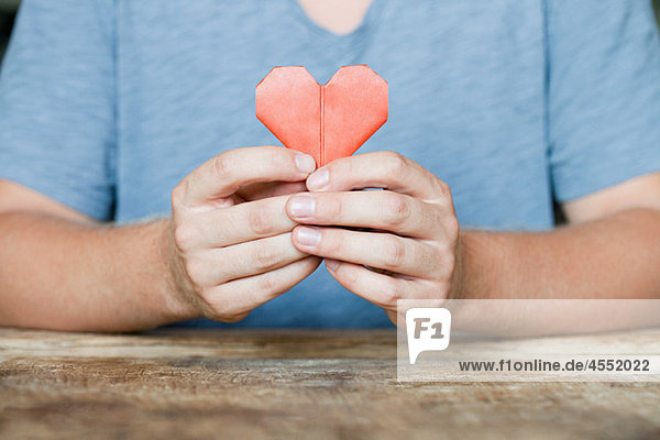Person holding origami heart