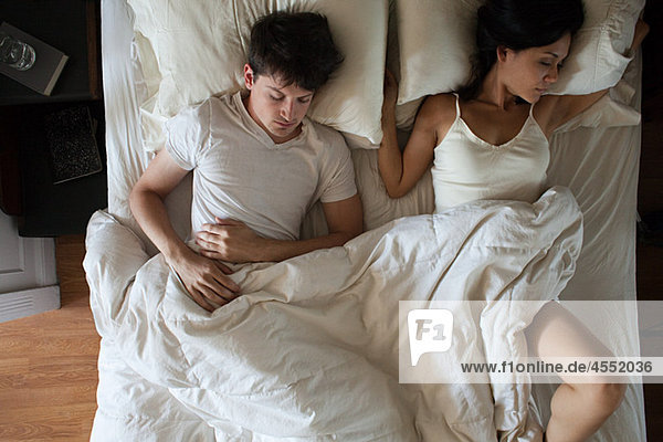 Junges Paar schläft im Bett