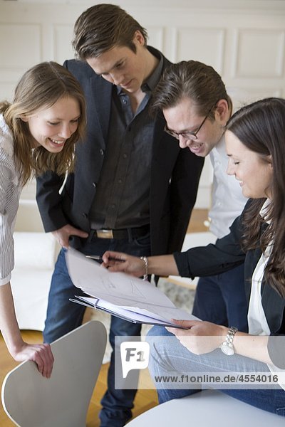 Group of young businesspeople smiling over documents