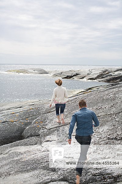 Couple walking on rocky shore