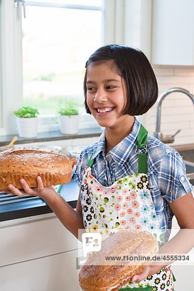 Mädchen hält loafs von Brot und lächelnd