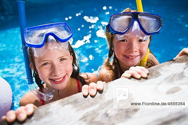 Portrait of sisters in swimming pool