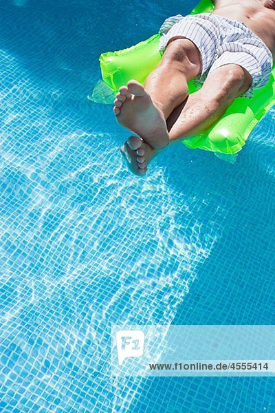 Man on inflatable raft in swimming pool