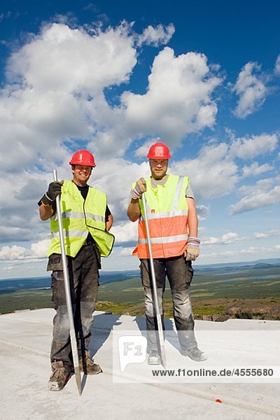 Arbeitnehmer-stehend auf Beton auf Baustelle