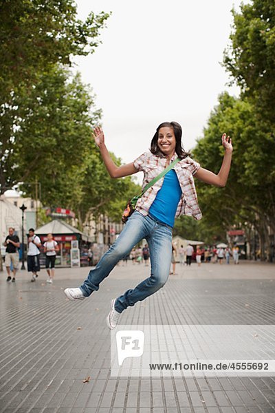 Portrait einer Frau in Stadt springen