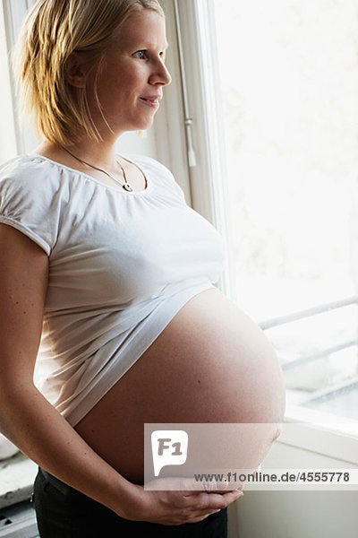 Schwangere Frau durch Fenster Suchen