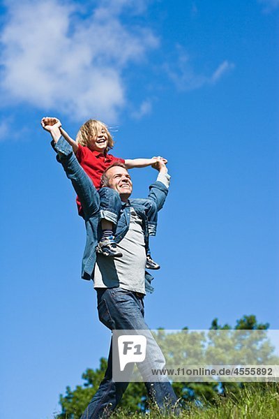 Vater Piggy Backing Tochter in nicht Städtisches Landschaft
