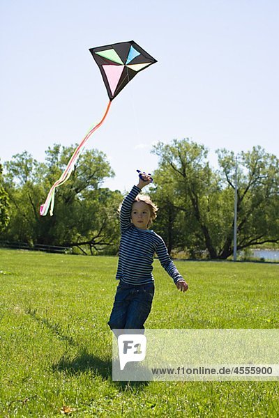 Boy flying Kite in hellem Sonnenlicht